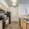 Garden-Style Apartments Near Target - Sterling Pointe - Kitchen with Wood-Style Flooring, Customized Cabinetry, Countertops, Range, Microwave, Dishwasher, and Refrigerator.